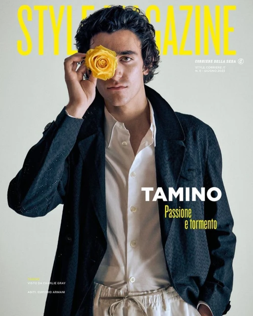 Magazine cover features a dark-haired male model with a yellow rose over his eye, wearing a dark jacket and light-colored pants.