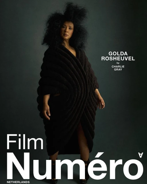Fashion editorial shot featuring a woman in a black sculptural garment against a muted grey backdrop, promoting Film Numero Netherlands.
