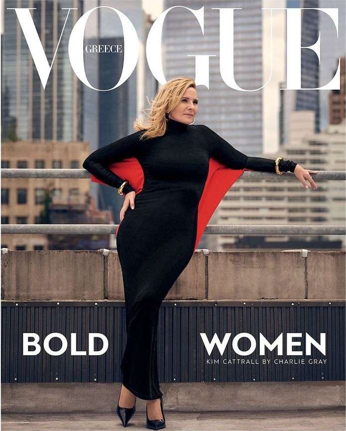 Magazine cover featuring an adult female model in a long black dress and red cape, posing on a rooftop with a city skyline backdrop.