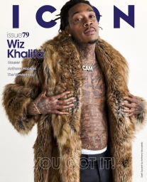Wiz Khalifa wearing a large fur coat over tattooed torso with a silver CAM chain necklace against a white background.