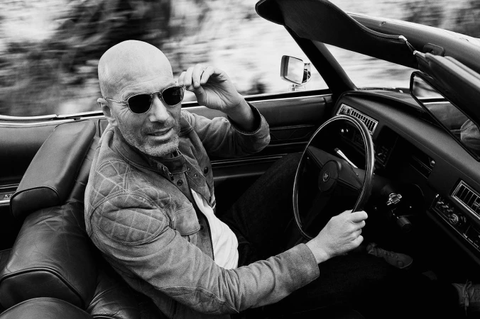 Zinedine Zidane wearing sunglasses and a quilted jacket driving a convertible car in London, photographed by Charlie Gray.