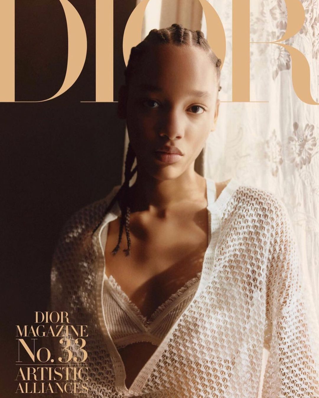 Fashion magazine cover featuring a woman with braided hair and a white crocheted top in front of a floral pattern curtain.