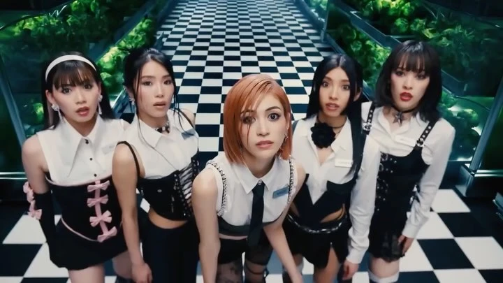 Five young Asian women in modern outfits pose indoors against a backdrop of green foliage and black-and-white checkered floor.