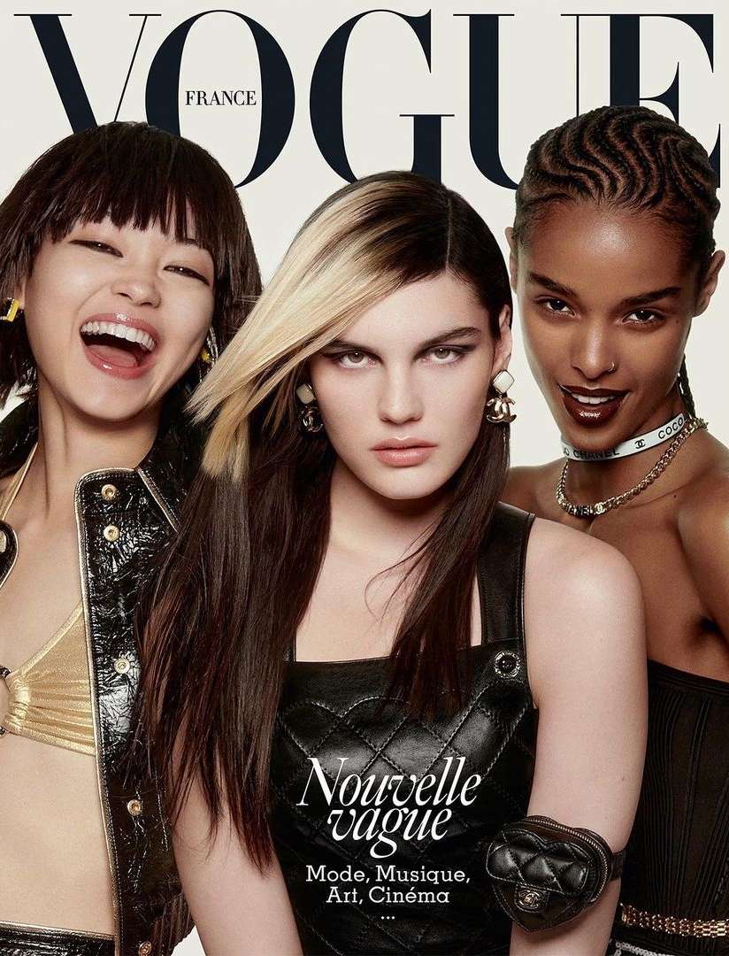 Vogue France magazine cover featuring three female fashion models with distinctive hairstyles, makeup, and jewelry posing closely together.