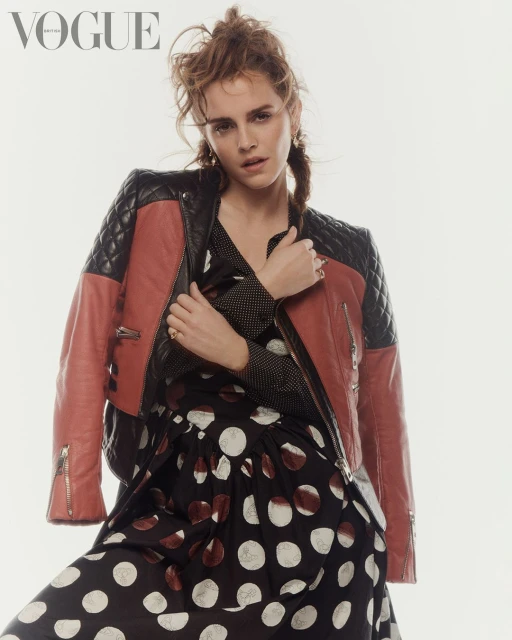 Emma Watson poses in a polka dot dress with a two-tone red and black leather jacket for a Vogue magazine fashion shot.