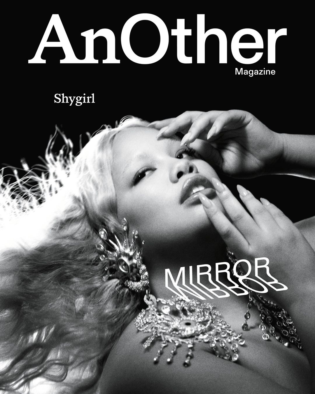 Magazine cover featuring a light-skinned woman with blonde hair, large earrings, and a necklace against a dark background.