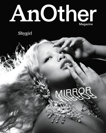 Magazine cover featuring a light-skinned woman with blonde hair, large earrings, and a necklace against a dark background.