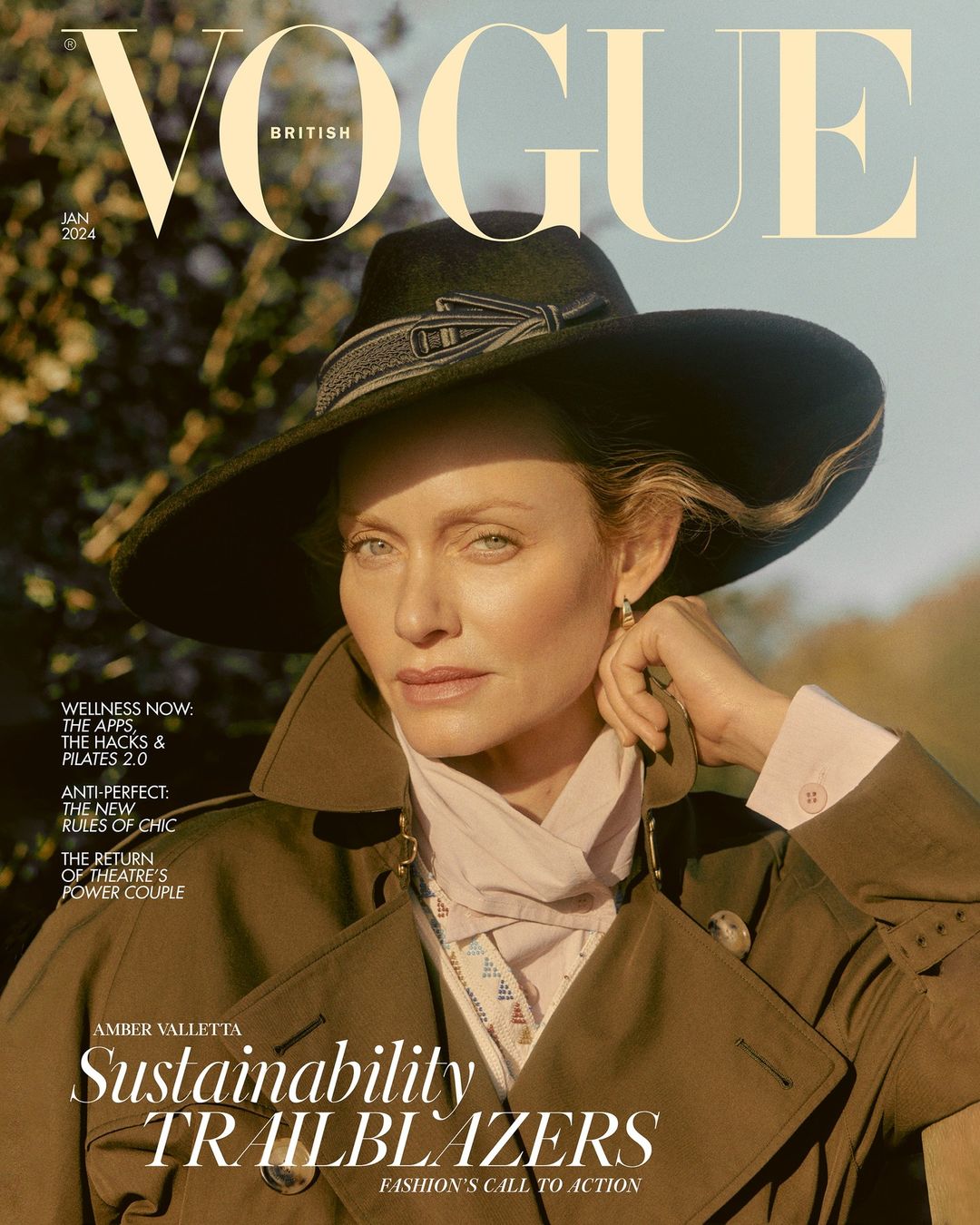 Amber Valletta wearing a wide-brimmed black hat and trench coat on British Vogue magazine cover by photographer Charlotte Wales