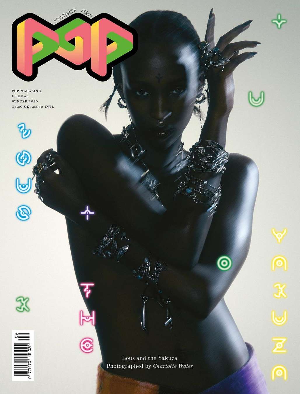 Magazine cover featuring an adult female model with dark skin wearing jewelry and fashionable clothing against a light background.