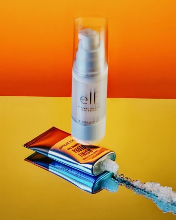 Cosmetics still life: a clear pump bottle of elf mineral infused face primer sits above a tube of Smashbox photo finish primer.