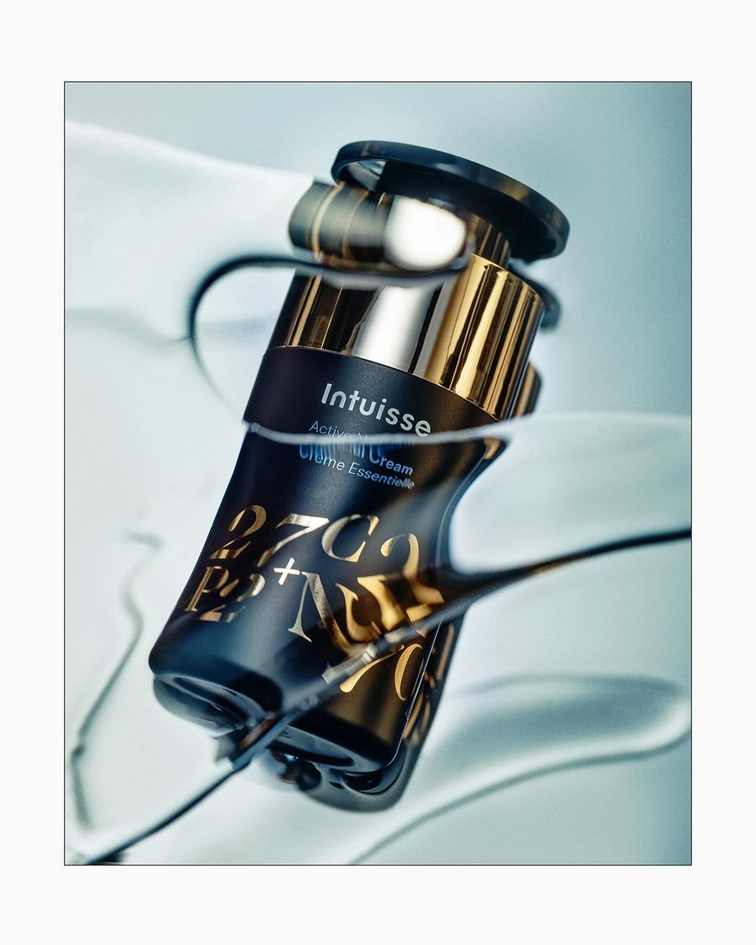 Cosmetic cream jar featuring elegant gold and black design, creating a luxurious skincare product image with water and clear liquid effects.