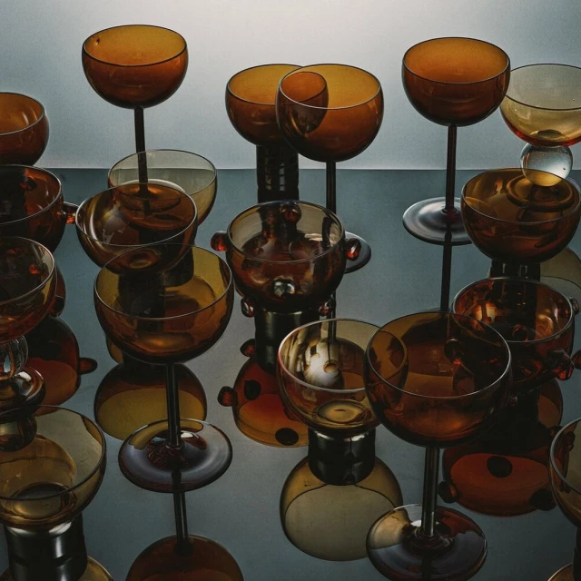 Still life with amber glassware set against a light gray background and surface, creating a warm, elegant, and reflective display.