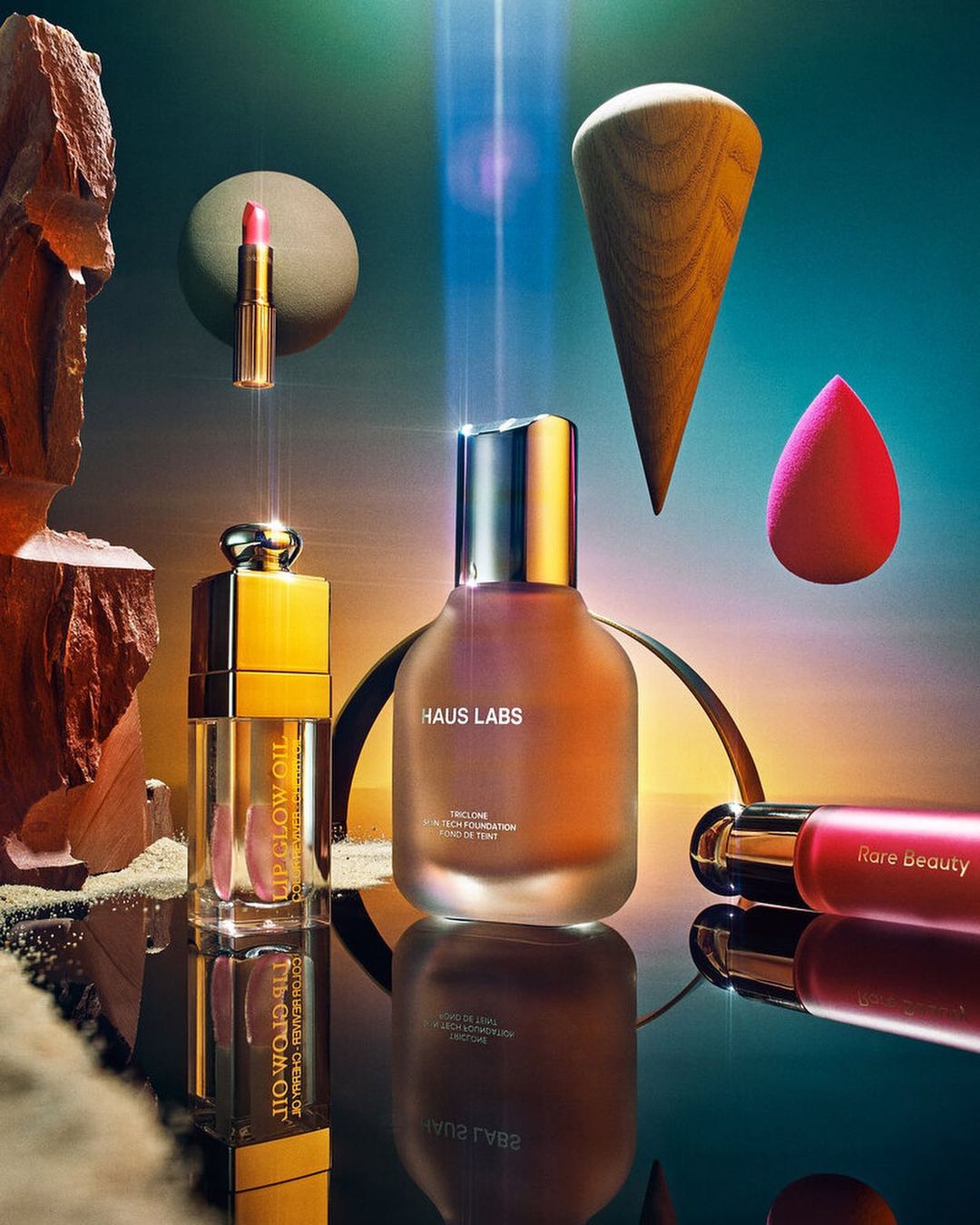 Several beauty products, including Haus Labs and Rare Beauty brands, are displayed with geometric shapes and a gradient background.