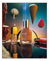 Cosmetics product photography by Chelsea Kyle featuring Haus Labs foundation and floating beauty props on a reflective surface