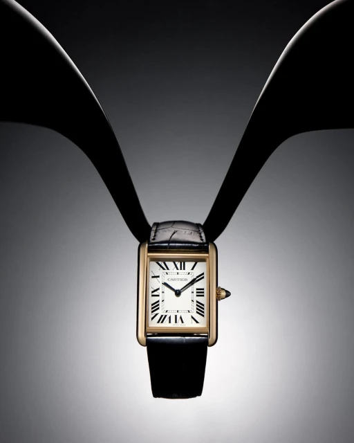 Elegant gold-tone wristwatch with a black leather strap is displayed on a graduated grey background with dark bands, fashion time.