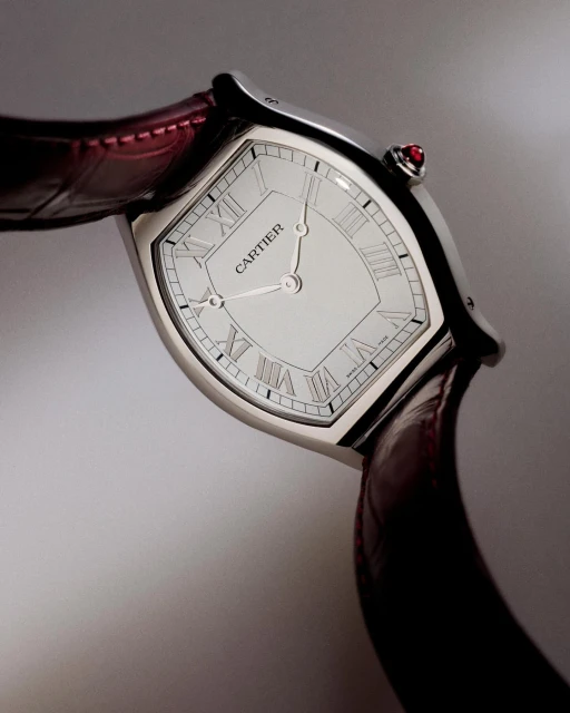 Elegant Cartier watch featuring a silver-tone case, white dial with Roman numerals, and a luxurious red leather strap, close-up studio shot.