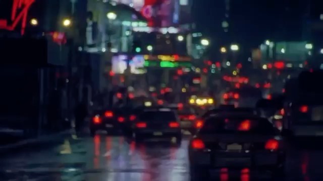 Nighttime city street with traffic, headlights, tail lights, and neon signs reflecting on the wet pavement, creating a vibrant urban scene.
