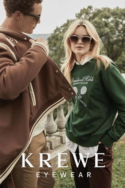 Two people pose outdoors for Krewe Eyewear fashion ad. An adult male and adult female wear sunglasses and fashionable fall clothing.