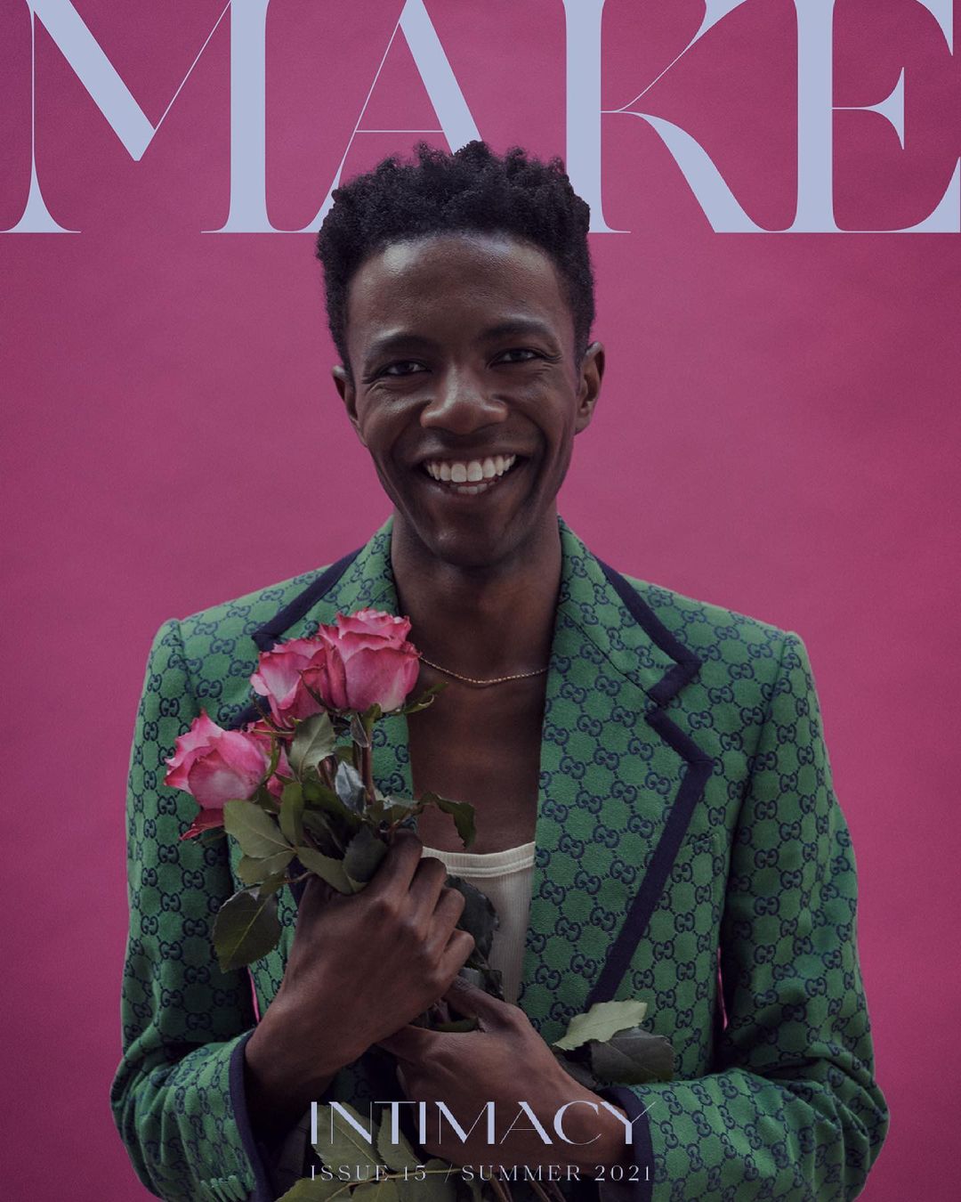 Magazine cover featuring a smiling adult male holding a bouquet of pink roses, wearing a Gucci blazer against a pink background.