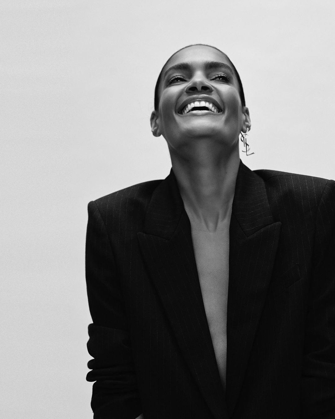 Portrait of a smiling woman wearing a dark blazer against a plain white background by Chloe Mallett