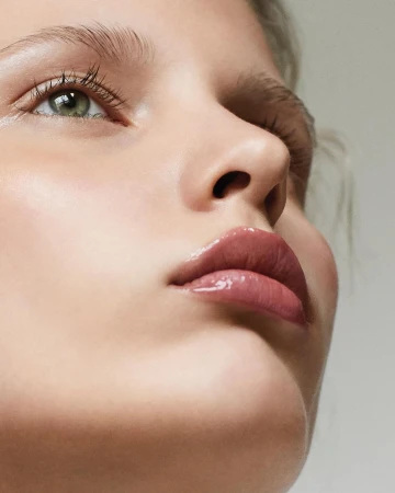 Extreme close-up beauty portrait of a woman with glossy mauve lips and natural makeup captured by Chris and Cory.
