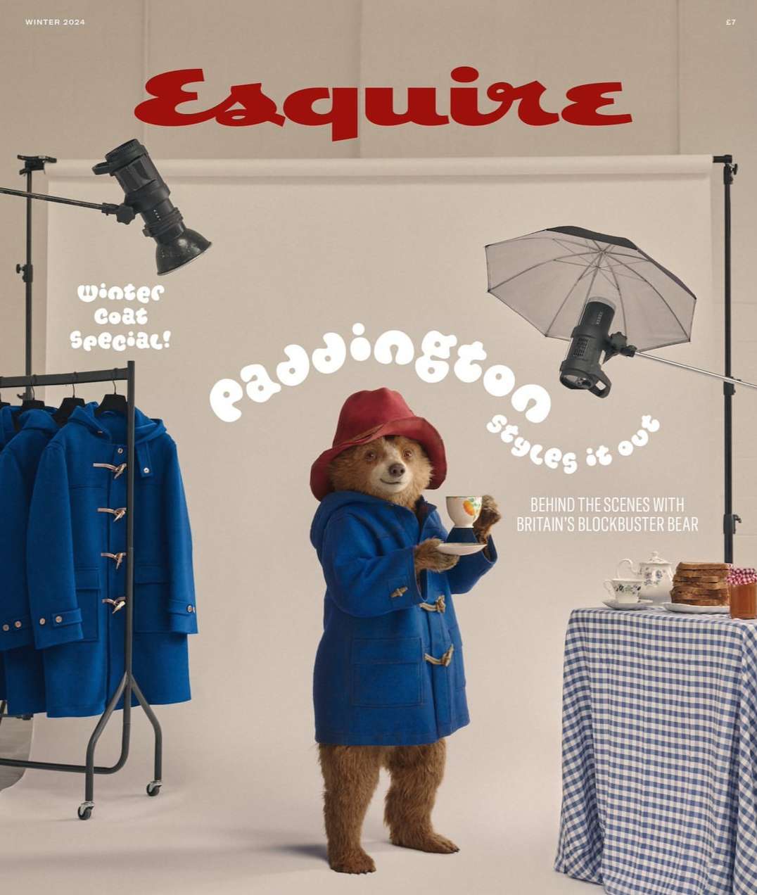 Esquire magazine cover featuring a Paddington bear character in a blue coat and red hat holding a teacup, set in a photo studio.