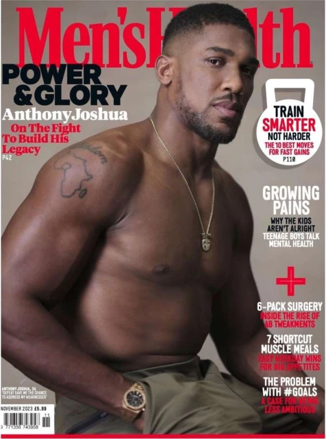 Men's Health magazine cover featuring Anthony Joshua, a muscular Black man, shirtless, wearing a watch and necklace, with magazine text.