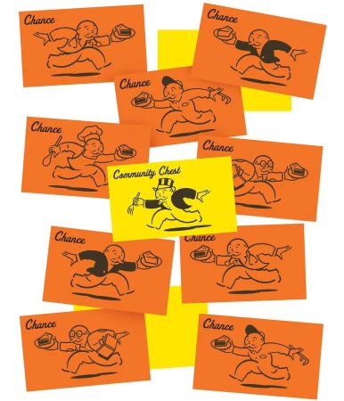 Overhead shot of 'Chance' and 'Community Chest' cards with cartoon illustrations of a businessman, chef, and other figures.