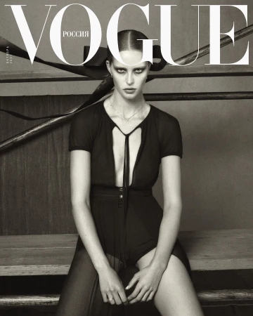 Black and white Vogue cover featuring a woman in a black outfit sitting on wooden steps with the masthead and text at the top.