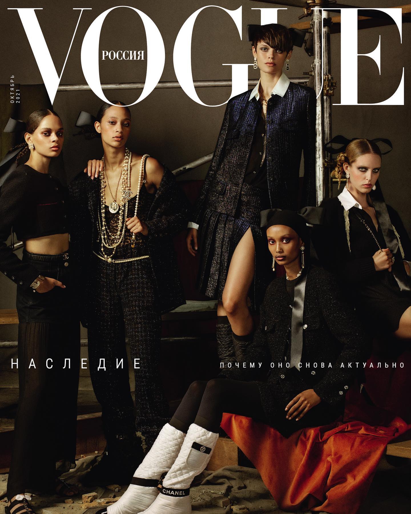Vogue Russia magazine cover featuring five fashion models wearing black and grey tweed clothing, posing indoors on an editorial fashion set.