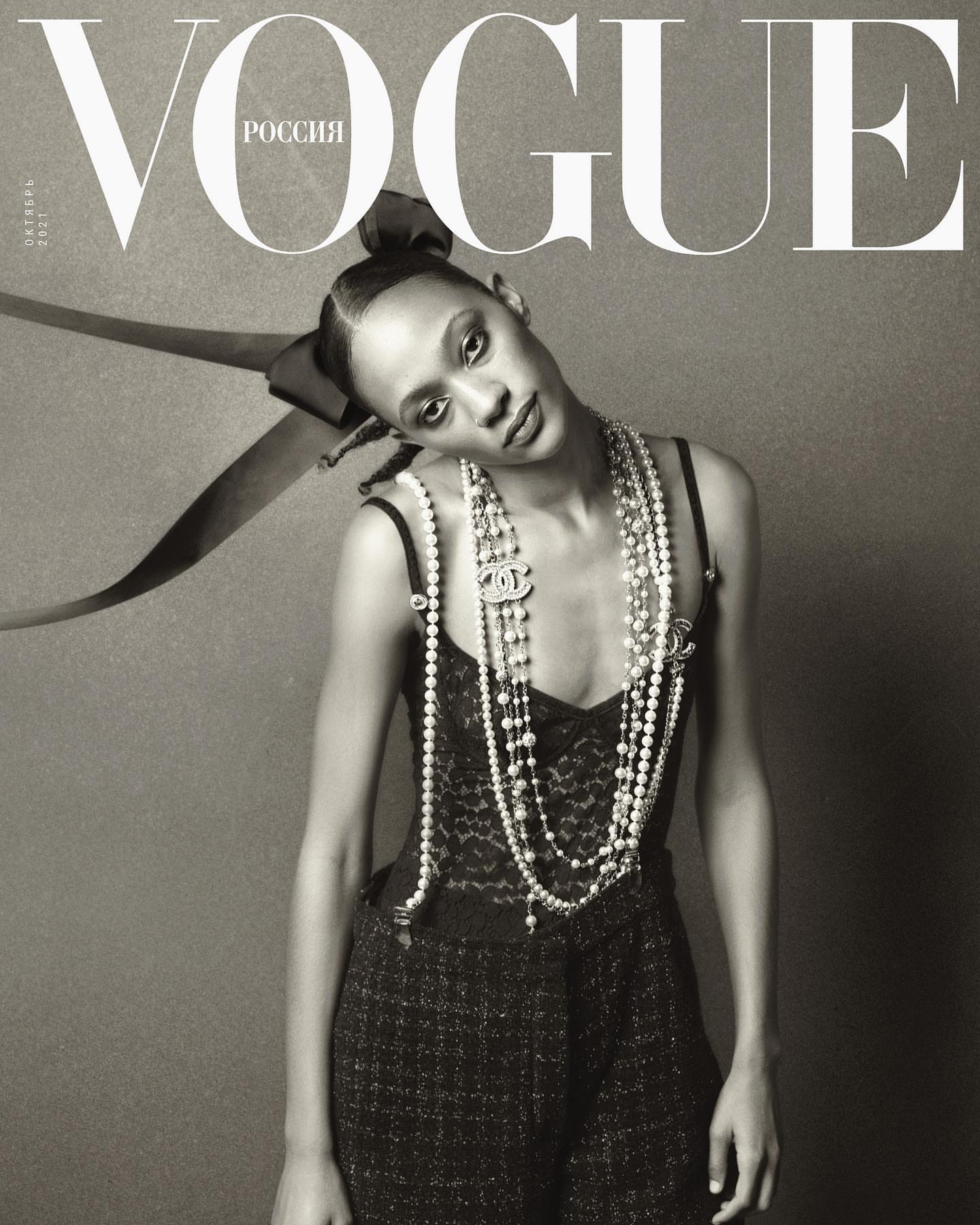 Vogue Russia cover featuring a woman with pearl necklaces and a bow, captured in black and white with high fashion elements.