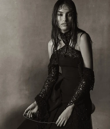 Model with wet hair wearing a black lace halter gown holding a thread by Christian Macdonald
