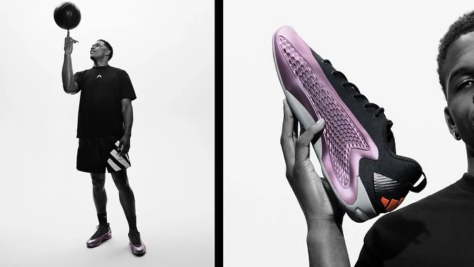 Black and white promotional shot of a male model spinning a basketball on his finger and holding a sneaker in front of a white background.