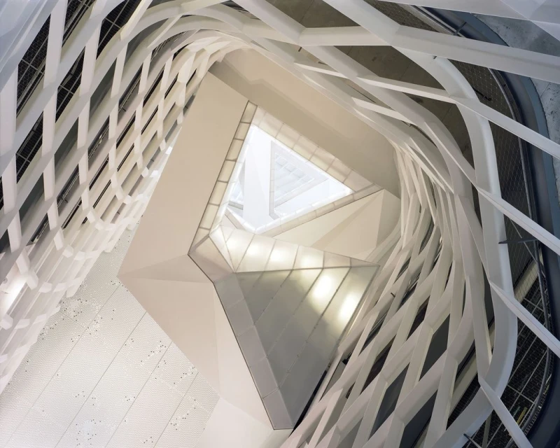Abstract architectural shot of an interior structure with white geometric designs and light, creating a modern and clean aesthetic.