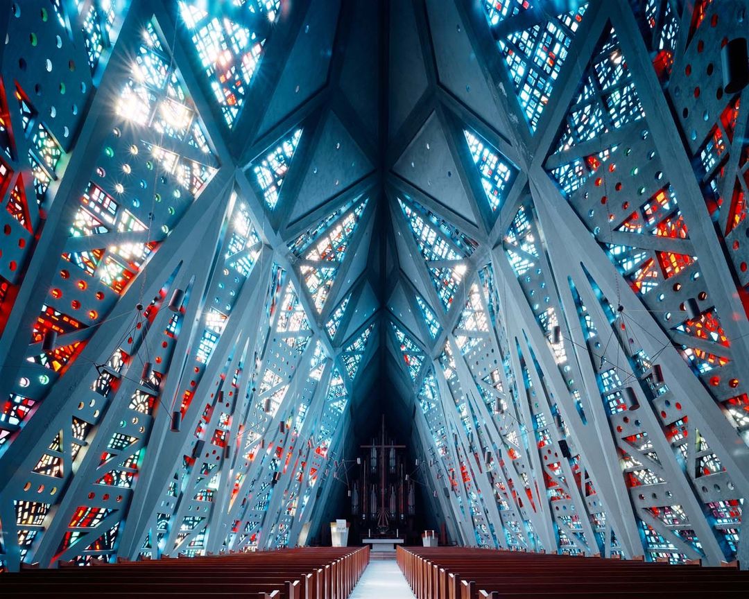 Interior view of Thorncrown Chapel in Eureka Springs, Arkansas featuring a unique architectural design with stained glass windows and wooden pews.