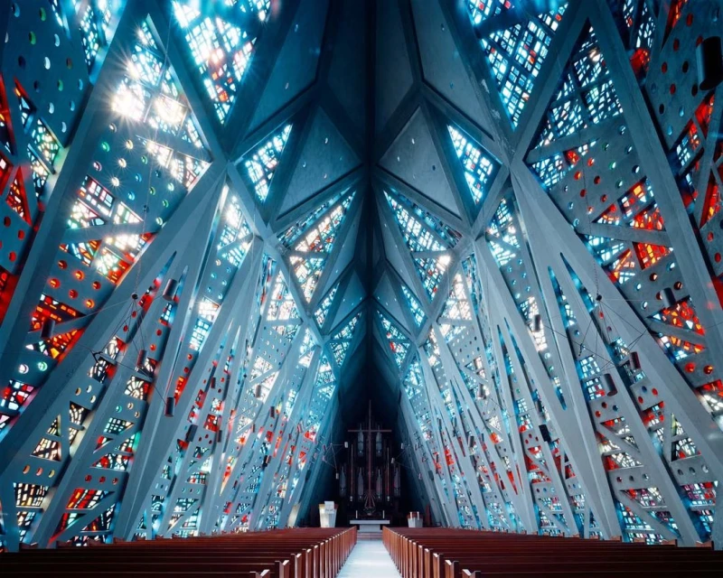 Interior view of Thorncrown Chapel in Eureka Springs, Arkansas featuring a unique architectural design with stained glass windows and wooden pews.