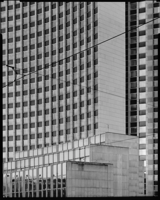 Monochrome architectural shot of a modern high-rise building with repetitive window patterns and stark lines, showcasing urban design.