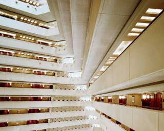 Interior architectural view looking up through the tiered balconies of a hotel atrium by Christoph Morlinghaus