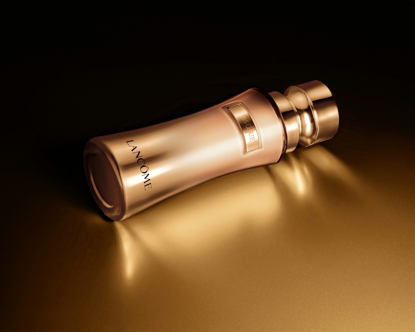 Elegant gold Lancôme Absolue skincare product bottle resting on a reflective gold surface in a photo studio setting with dark background.