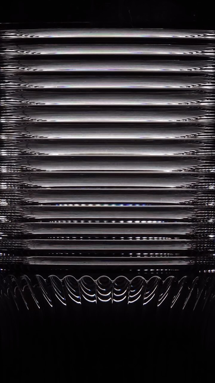 Abstract pattern of dark horizontal lines with white borders and half-circle shapes at the bottom against a dark background.