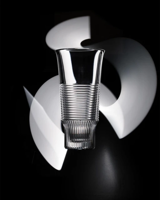 Elegant crystal glass with ribbed details on a dark backdrop with blurred white light streaks creating a dynamic, eye-catching visual effect.