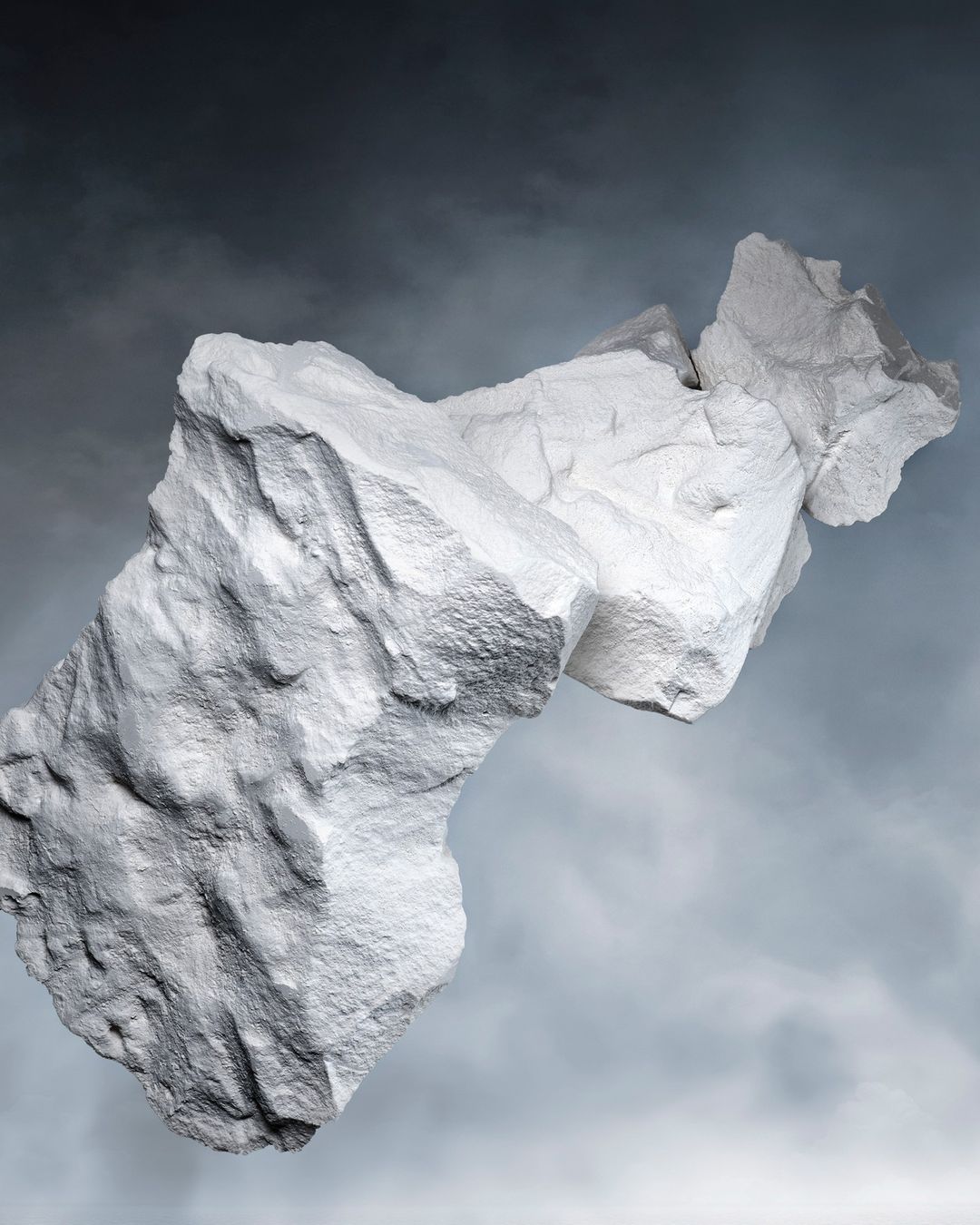 Abstract digital art of two large white rocks floating in a gray cloudy sky, creating a surreal and visually striking landscape.