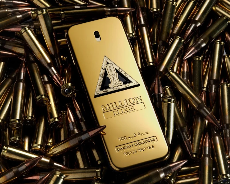 A close-up studio shot features a golden perfume bottle surrounded by scattered bullet casings, creating a bold and luxurious composition.
