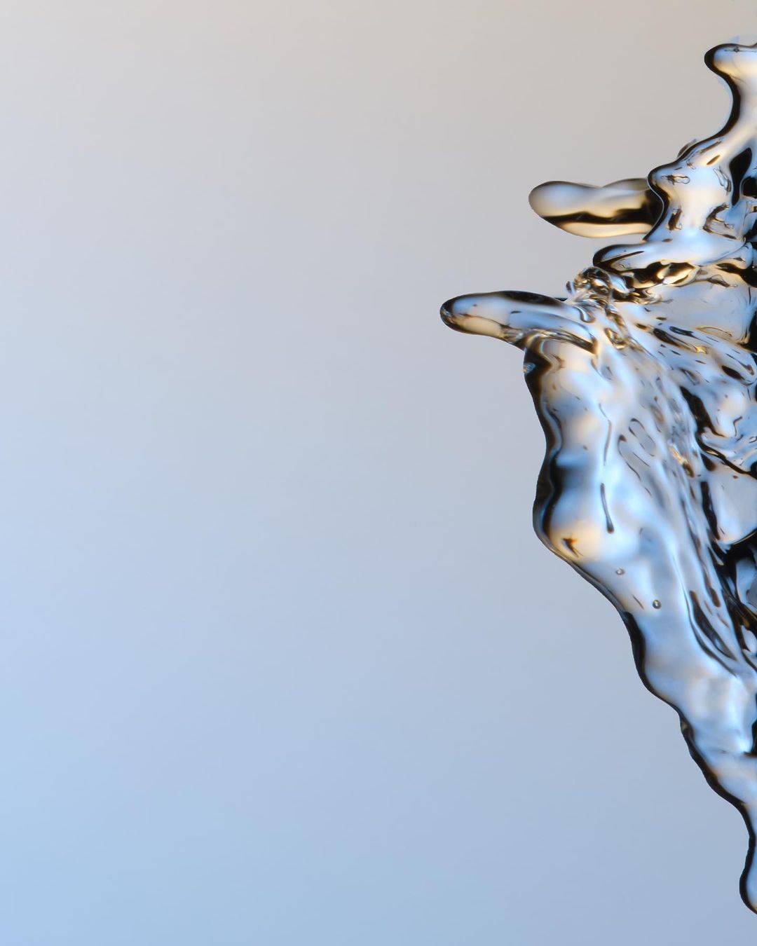 Abstract water splash against light blue background. Clean transparent liquid with varied textures and dynamic forms.