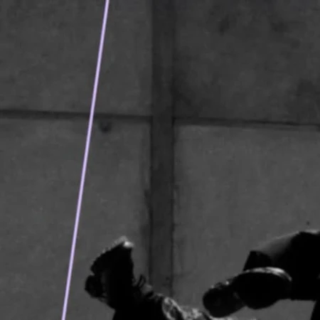 Monochromatic shot of an adult and child in darkness, embracing, with feet and lower bodies primarily visible.