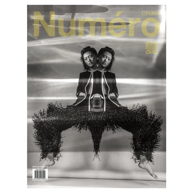 Fashion magazine cover featuring a symmetrical photo of an Asian female model wearing an outfit with fringe, shot in black and white.