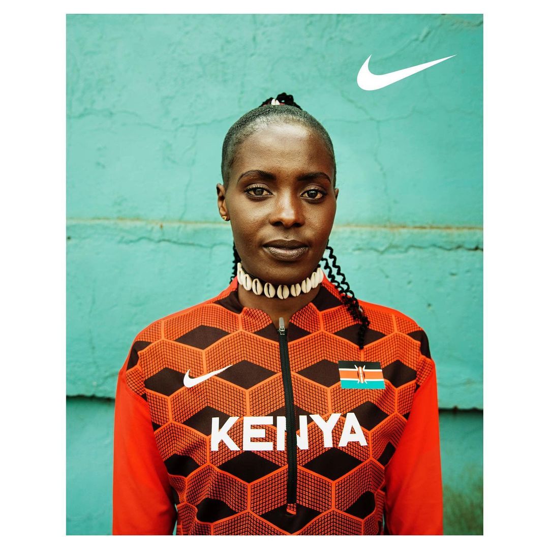 Portrait of an adult female athlete wearing a patterned athletic jacket with the Nike logo and the word 'Kenya' on the front.