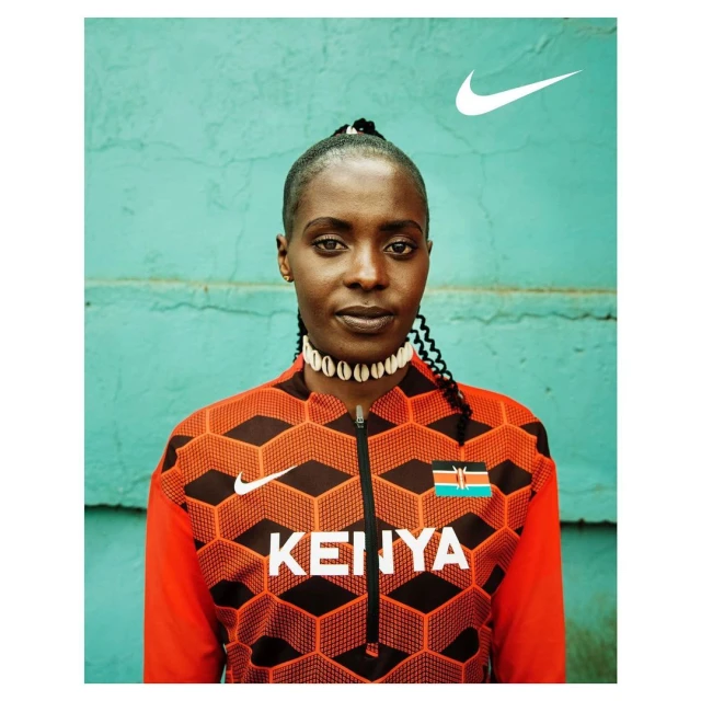 Portrait of an adult female athlete wearing a patterned athletic jacket with the Nike logo and the word 'Kenya' on the front.