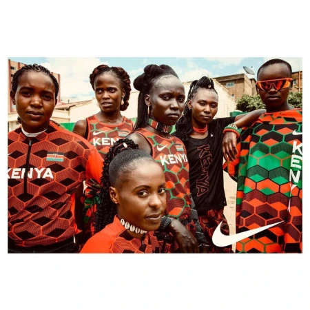 Six Kenyan women in athletic wear pose outdoors, showcasing colorful geometric designs and Nike branding, with an urban setting backdrop.
