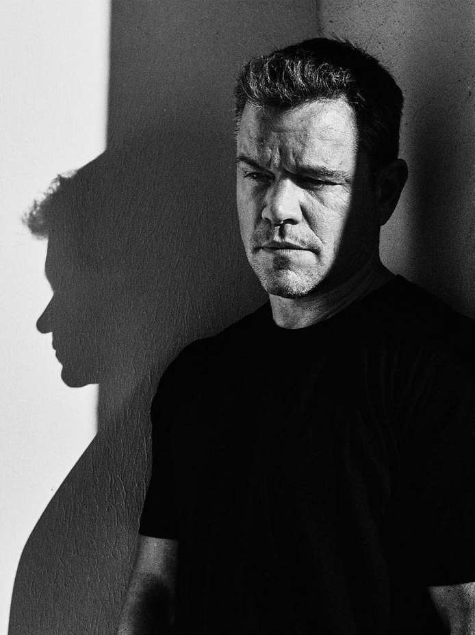 Black and white portrait of an adult man with a shadow. Close-up shot of a man looking off to the side.